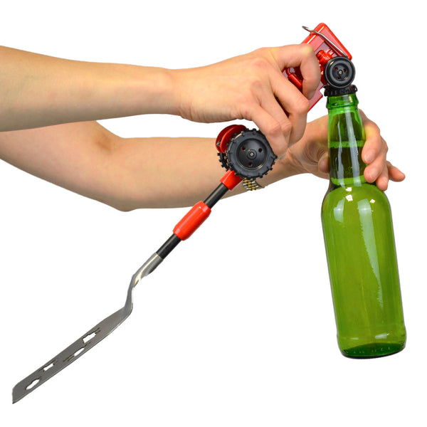 The Gibson Tractor BBQ Spatula is shown in red with the bottle opener feature, opening a green glass bottle of soda.